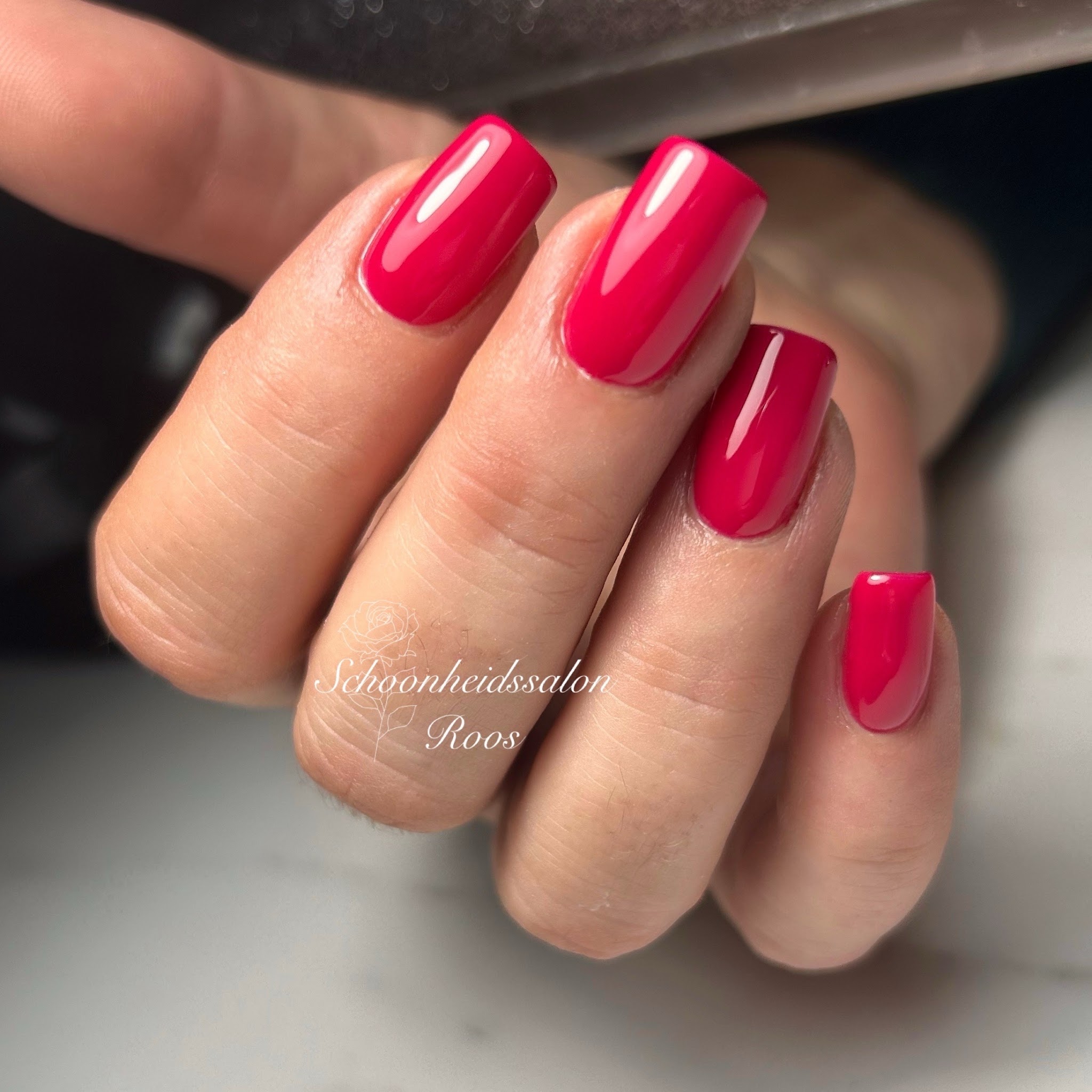 Rode gelnagels op een hand